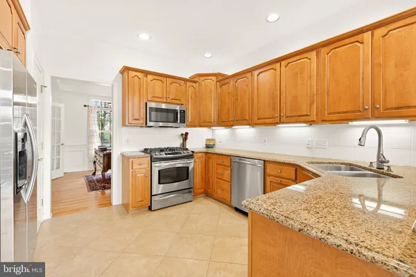 a kitchen with stainless steel appliances granite countertop a stove a sink and a microwave