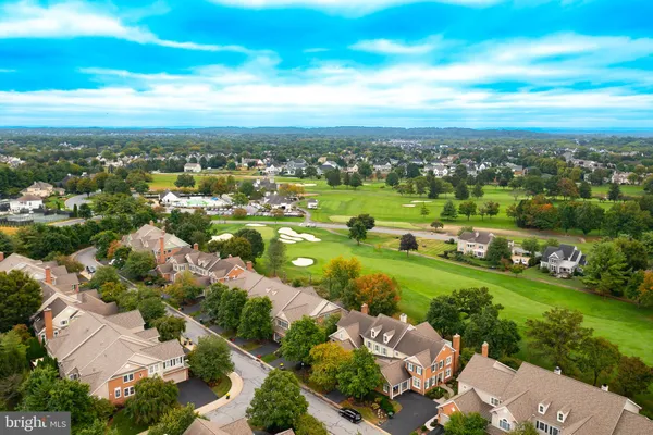 an aerial view of residential houses with outdoor space and trees