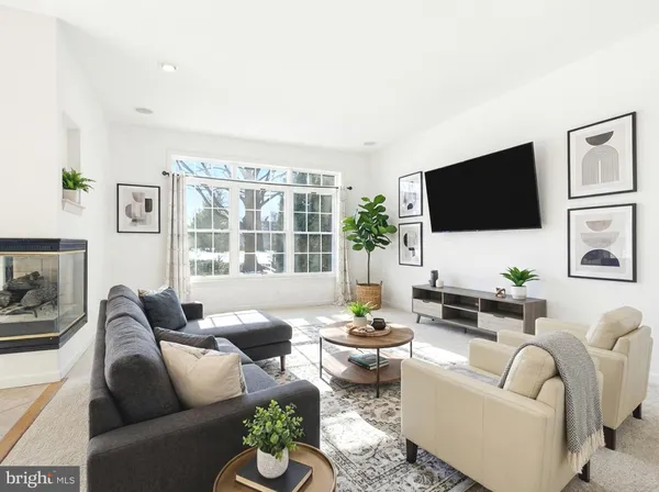 a living room with furniture a flat screen tv and a large window
