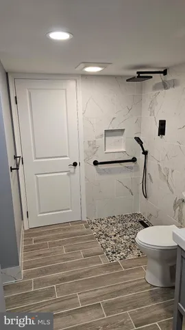 a bathroom with a shower toilet and a window