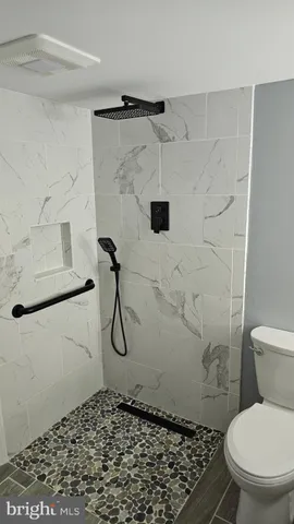 a bathroom with a toilet a sink and mirror