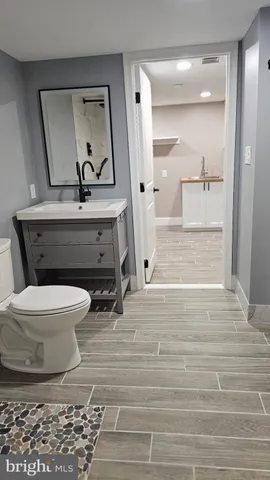 a bathroom with a sink a toilet and mirror