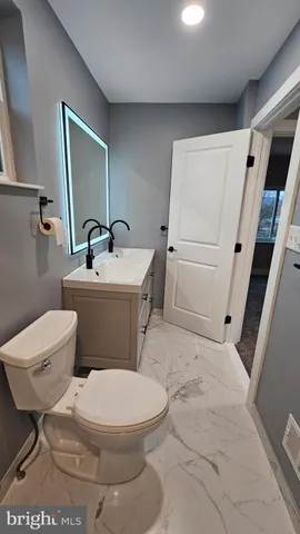 a bathroom with a sink a toilet and mirror