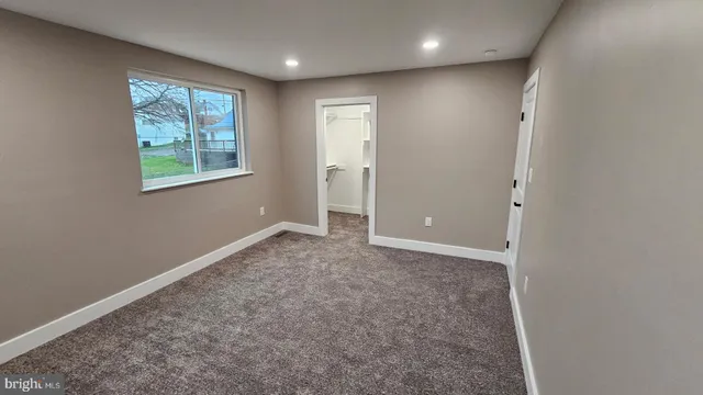 an empty room with windows and closet