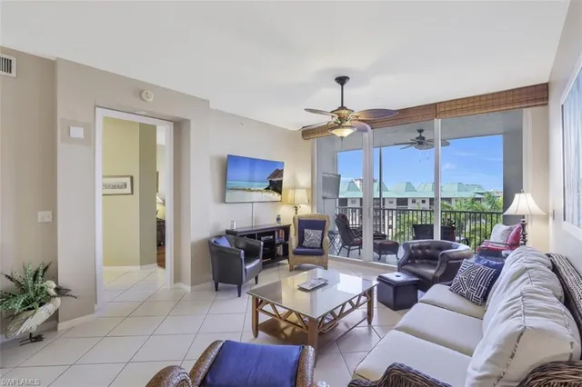 a living room with furniture a chandelier and a dining table