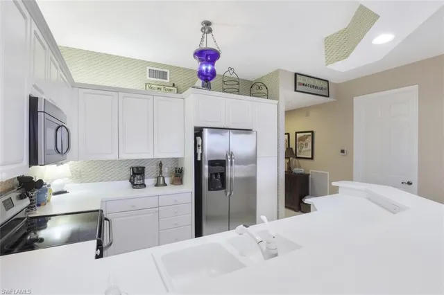 a kitchen with a refrigerator sink and cabinets