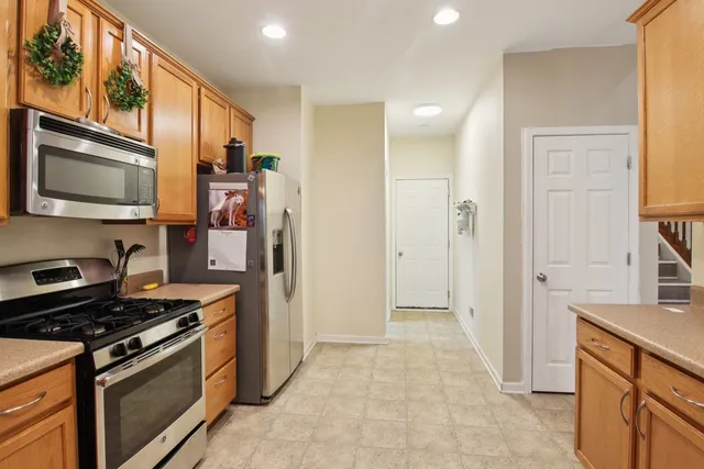 a kitchen with stainless steel appliances granite countertop a stove a refrigerator and a microwave