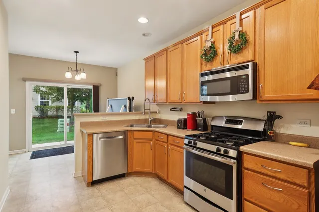 a kitchen with stainless steel appliances granite countertop a stove a sink and a microwave