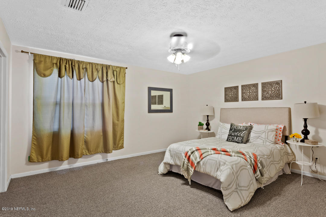 11366 Harts Road Jacksonville, FL 32218 - Photo 10 of 23 a bedroom with a bed and a chandelier