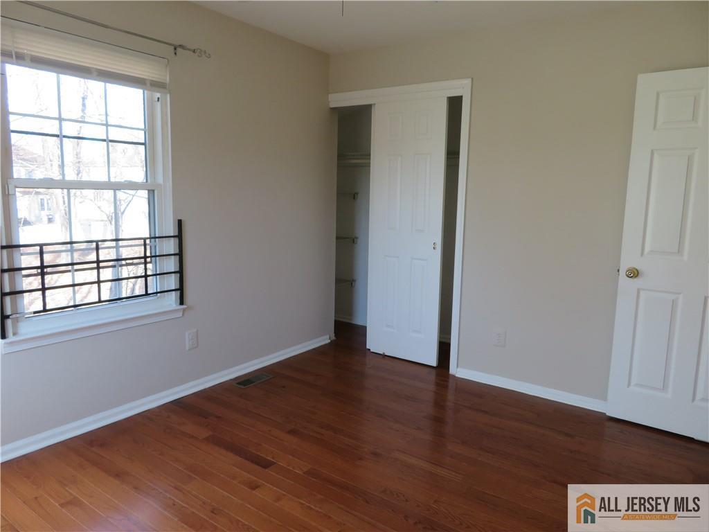 601 Maplecrest Road Edison, NJ 08820 - Photo 13 of 27 an empty room with wooden floor and windows