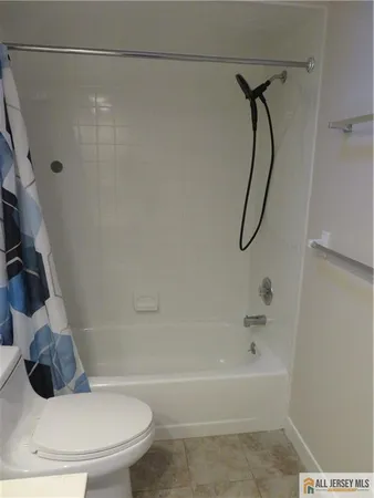 a white toilet sitting next to a bath tub