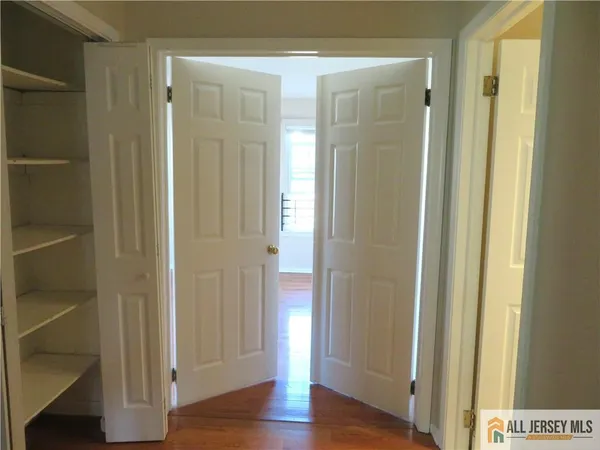 an empty room with wooden floor and a ceiling fan