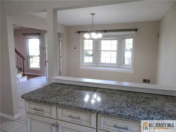 a kitchen with stainless steel appliances granite countertop a refrigerator a sink a stove and white cabinets