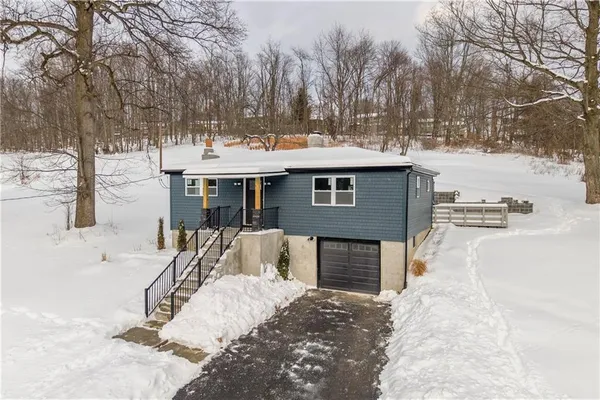 a view of a house with a yard covered in snow