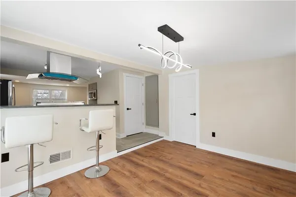 a kitchen with a wooden floor and white cabinets
