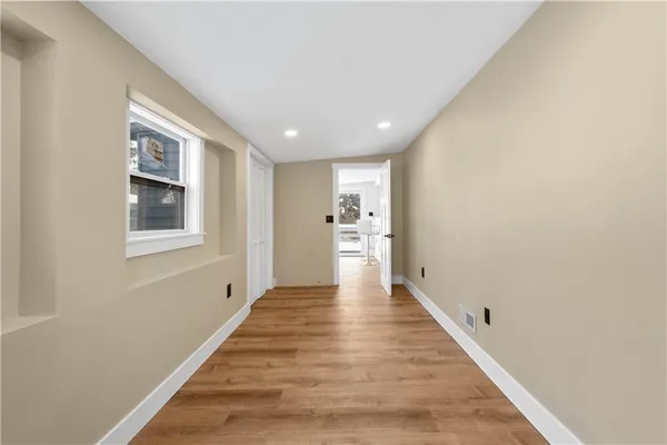 a view of a hallway with wooden floor and entryway