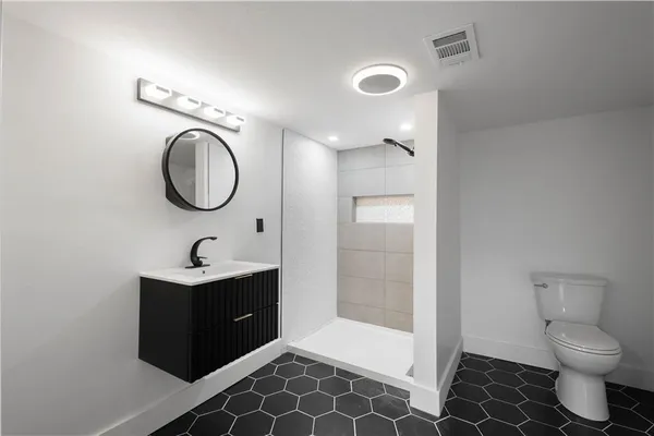 a bathroom with a toilet a sink and mirror