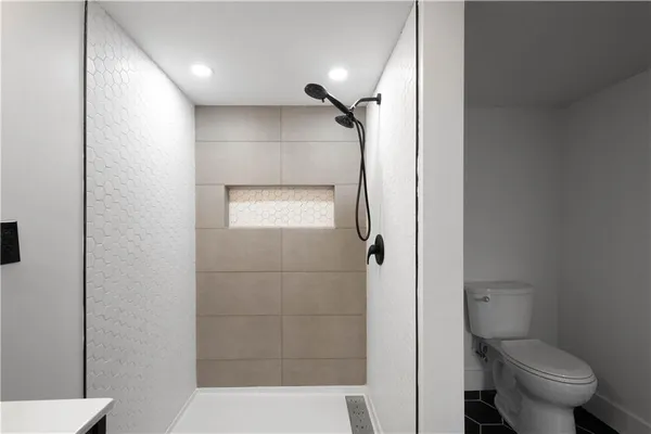 a bathroom with a granite countertop toilet a sink and shower