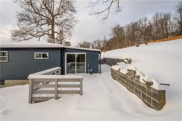 a front view of a house with a large tree