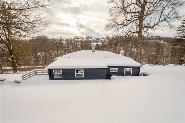 a white house that has a tree covered with snow