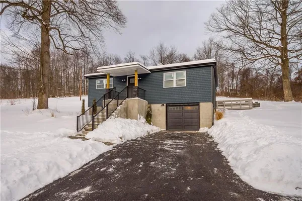 a view of a house with a yard covered in snow