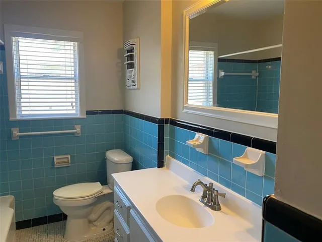 a bathroom with a toilet sink and mirror