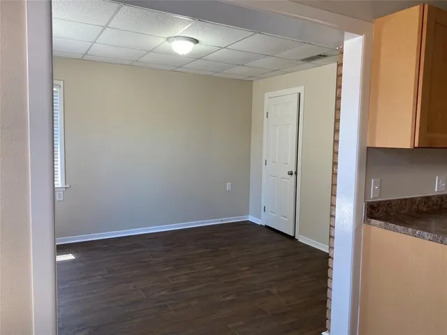 a view of an empty room with wooden floor and a cabinet