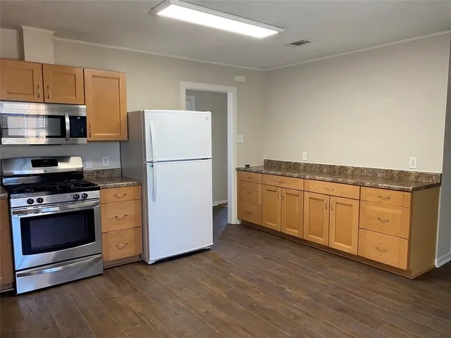 a kitchen with granite countertop white cabinets and white appliances
