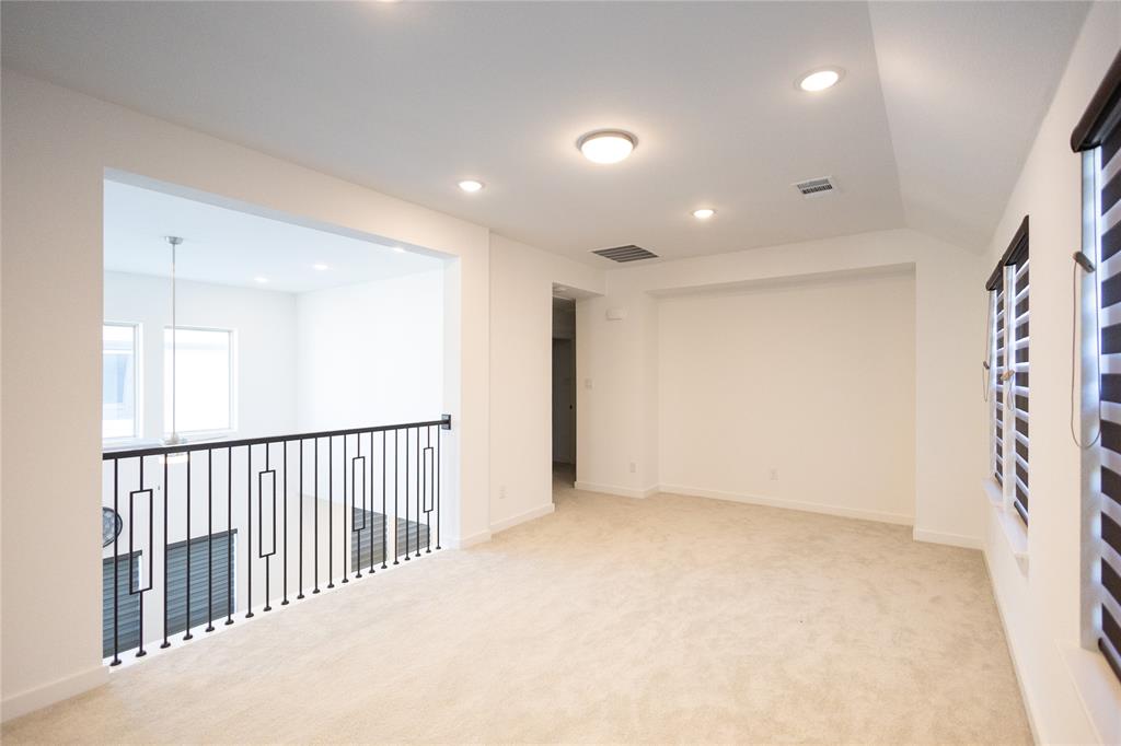 3017 Andorra Road McKinney, TX 75071 - Photo 31 of 40 Spacious loft-style room featuring light-finish wood flooring, recessed ceiling lighting, and a modern metal railing system overlooking a lower level