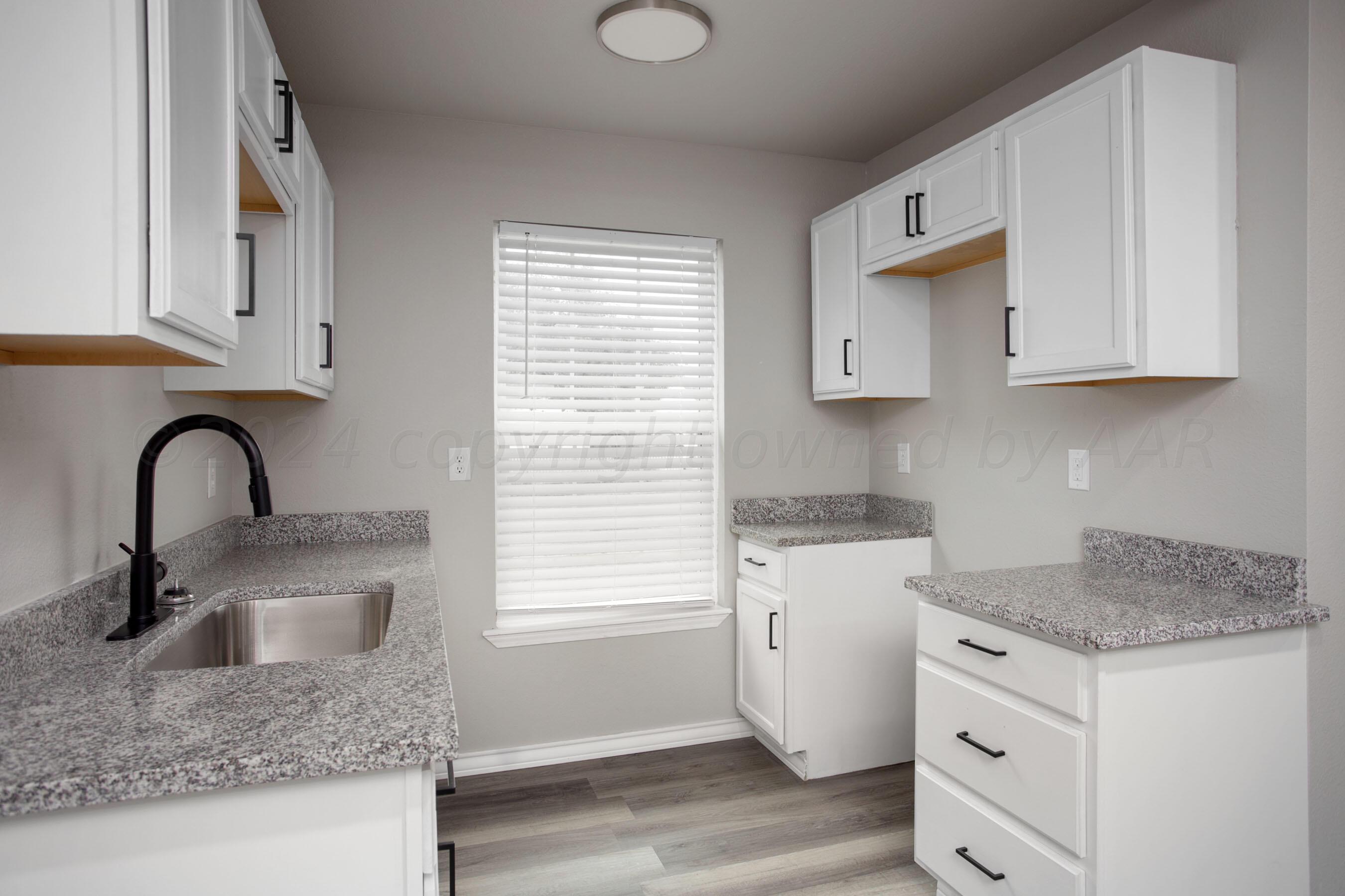 4118 South Monroe Street Amarillo, TX 79110 - Photo 8 of 25 a kitchen with granite countertop white cabinets and a sink