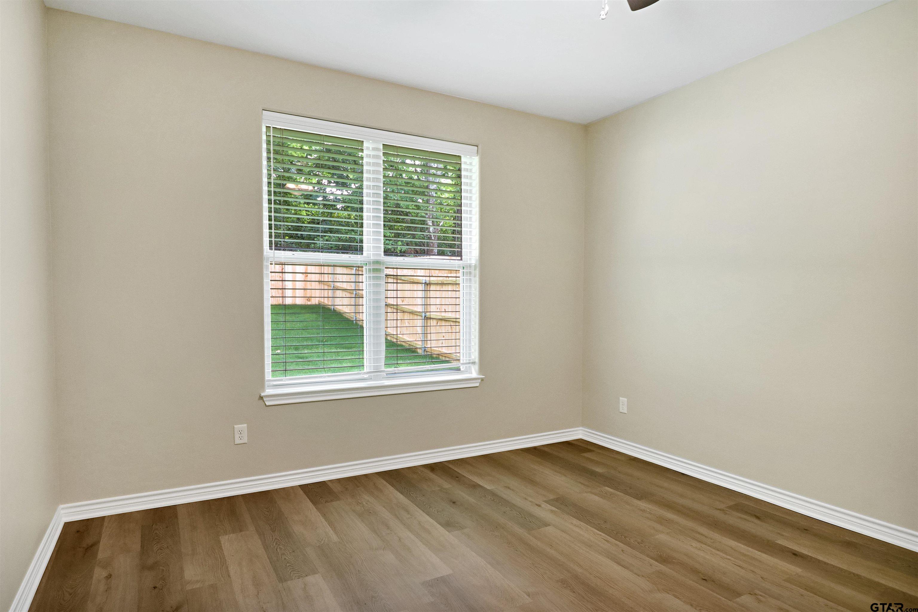 3053 Guinn Farms Road Tyler, TX 75707 - Photo 17 of 32 an empty room with wooden floor and windows