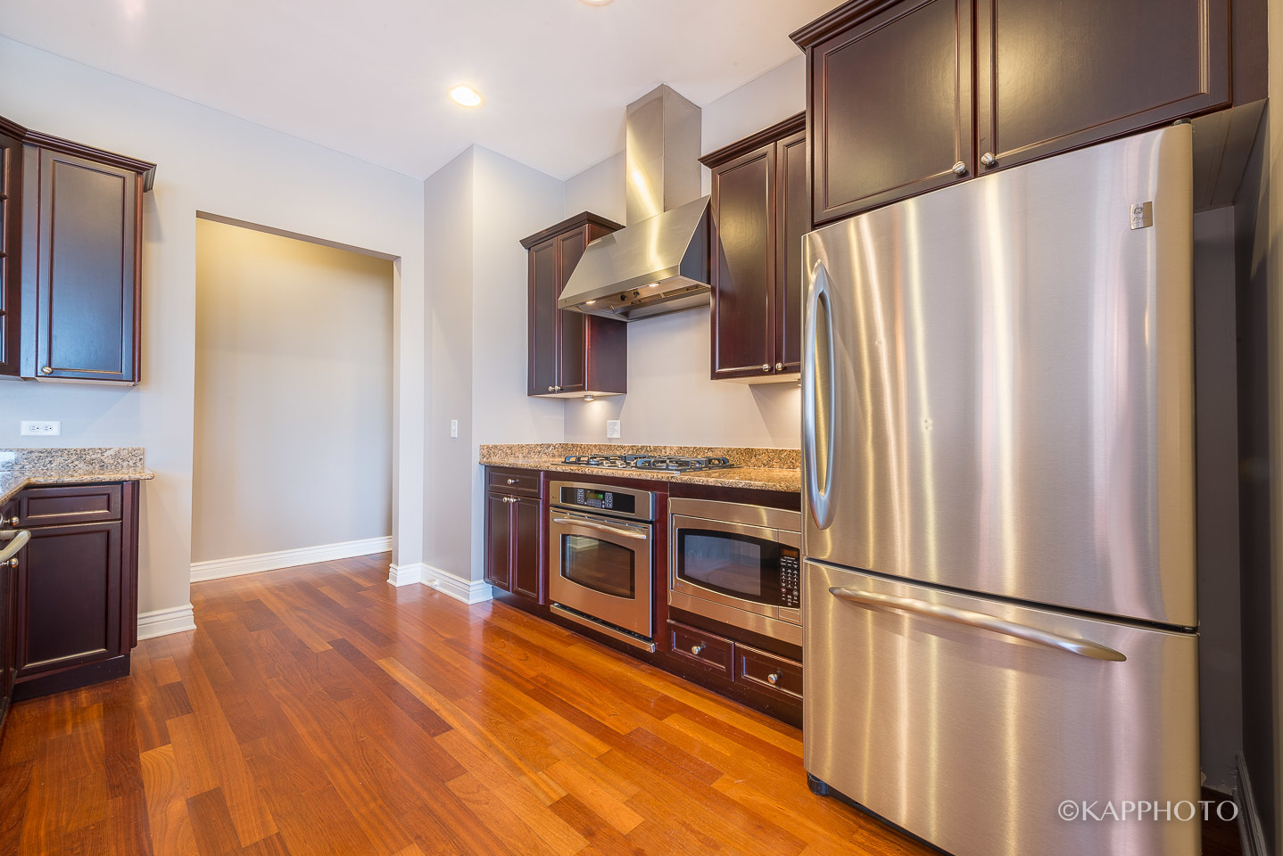 1148 West Monroe Street, Unit 6SW Chicago, IL 60607 - Photo 3 of 15 a kitchen with stainless steel appliances a refrigerator and wooden floor