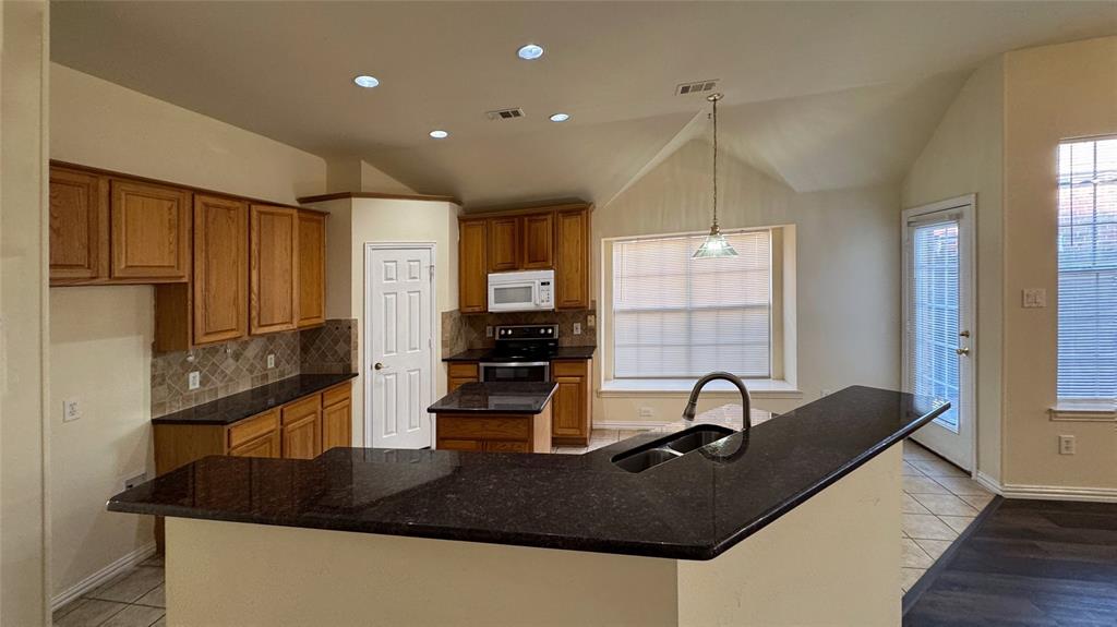 405 Colony Drive Allen, TX 75013 - Photo 12 of 17 a kitchen with kitchen island granite countertop a sink stainless steel appliances and cabinets
