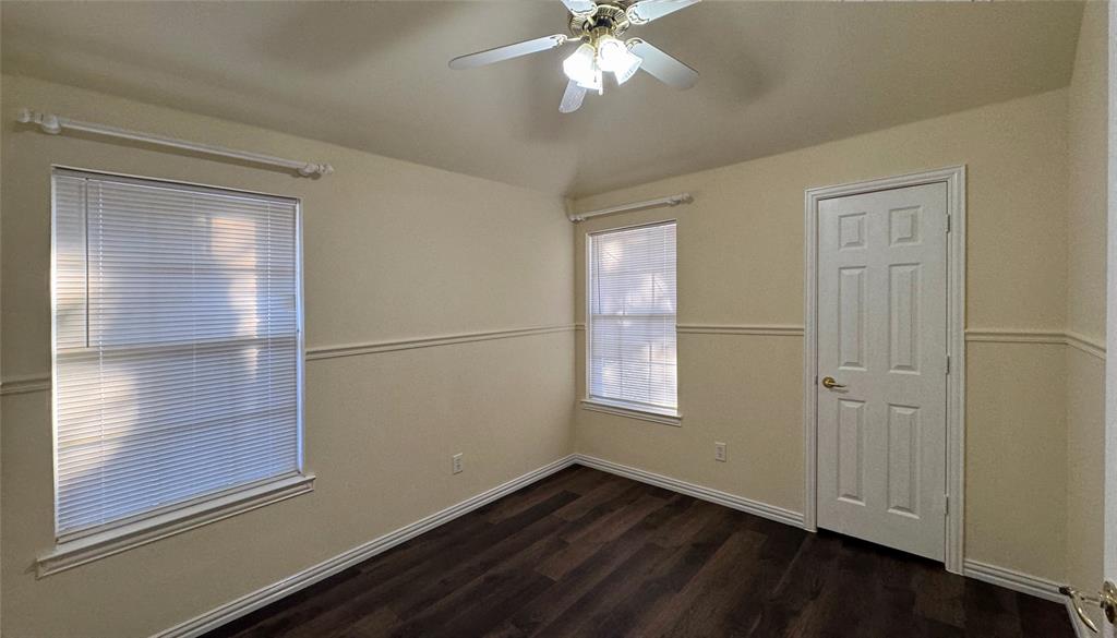 405 Colony Drive Allen, TX 75013 - Photo 14 of 17 an empty room with wooden floor cabinet and windows