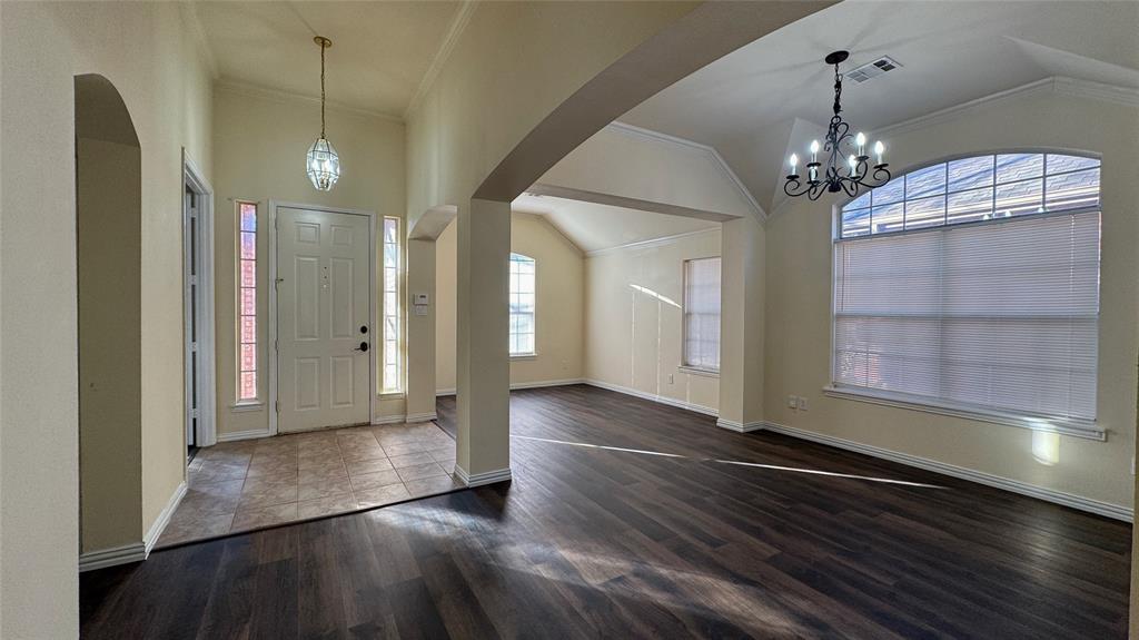 405 Colony Drive Allen, TX 75013 - Photo 2 of 17 a view of a hallway with wooden floor and a chandelier