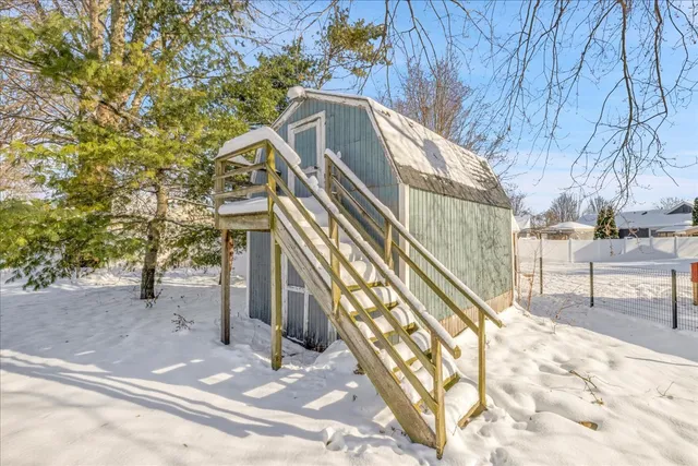 a view of a house with large trees and playing area