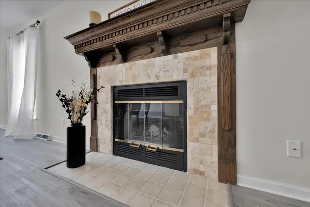 a view of a livingroom with wooden floor and a fireplace