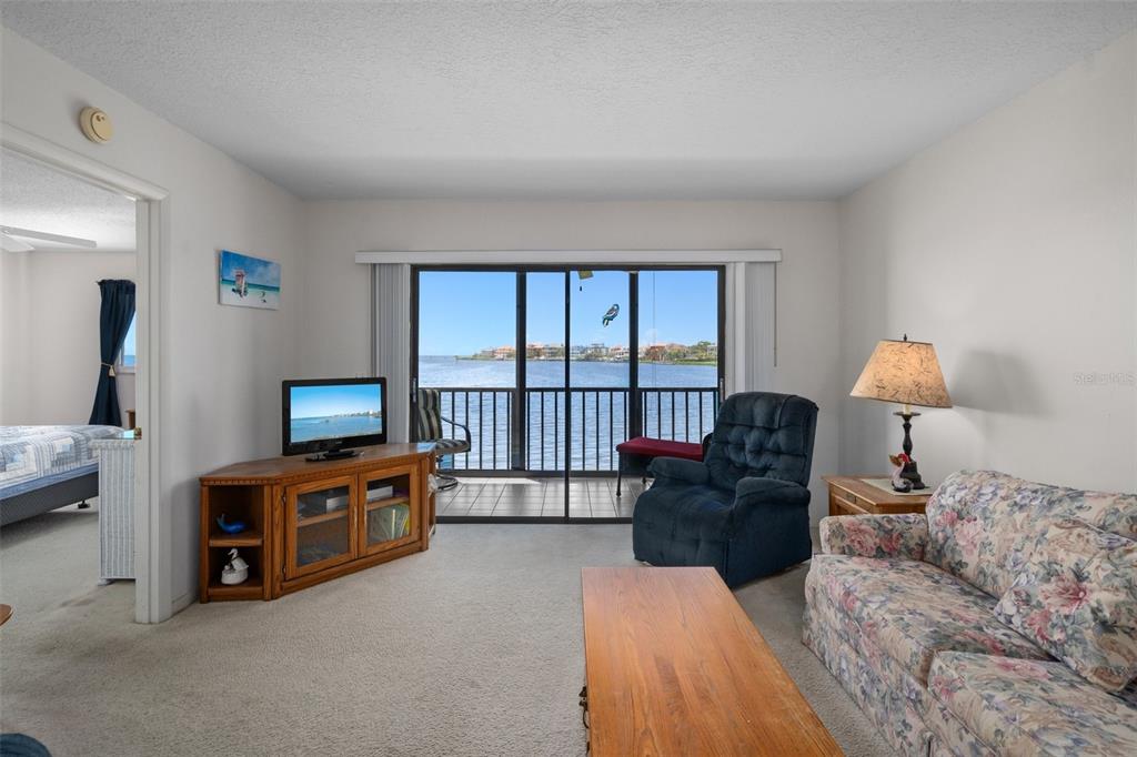 8211 Brent Street, Unit 816 Port Richey, FL 34668 - Photo 11 of 52 a living room with furniture a flat screen tv and a lamp