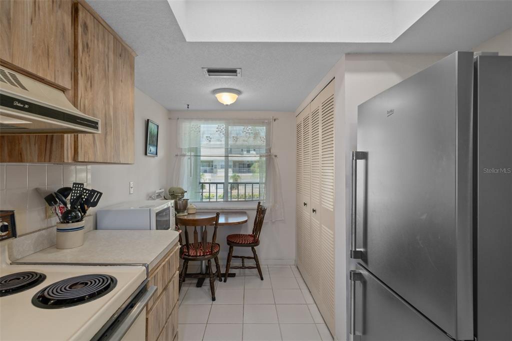 8211 Brent Street, Unit 816 Port Richey, FL 34668 - Photo 17 of 52 a kitchen with a dining table chairs and white stainless steel appliances