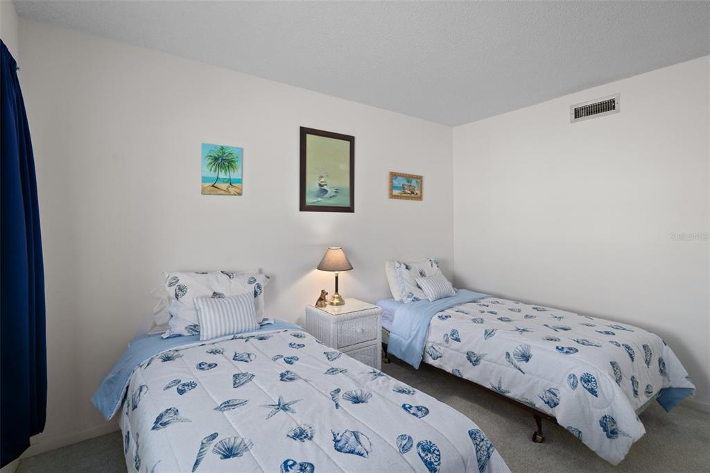 8211 Brent Street, Unit 816 Port Richey, FL 34668 - Photo 31 of 52 a bedroom with two beds and a lamp