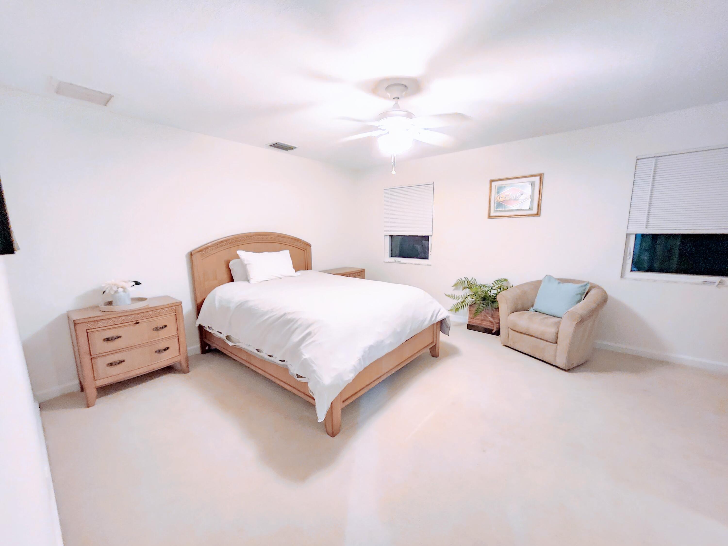 3567 Commodore Circle Delray Beach, FL 33483 - Photo 43 of 76 a bedroom with a bed and a chandelier