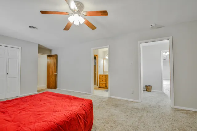 a bedroom with a bed and a ceiling fan