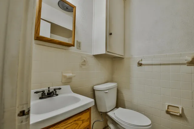 a bathroom with a sink a toilet and mirror