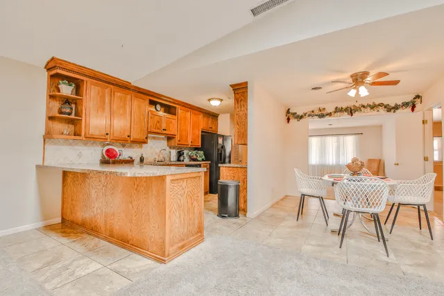 a kitchen with stainless steel appliances granite countertop a refrigerator and a stove top oven