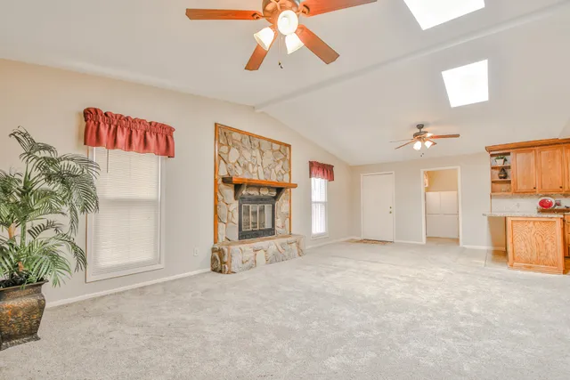 an empty room with windows and ceiling fan