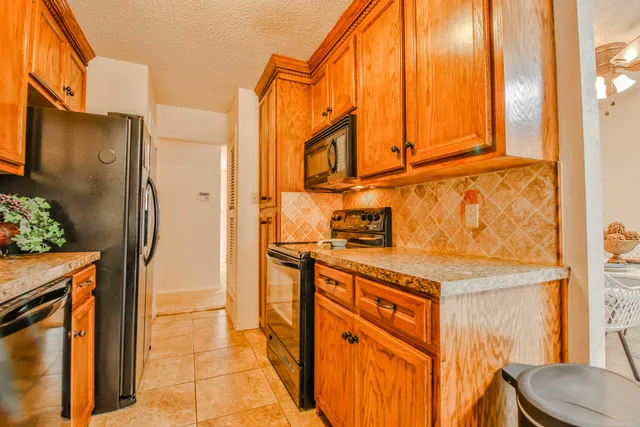 a kitchen with stainless steel appliances granite countertop a refrigerator and a stove