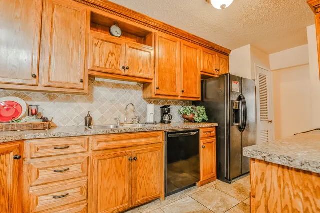 a kitchen with stainless steel appliances granite countertop a refrigerator and cabinets
