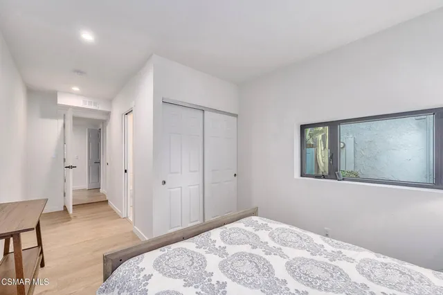 a bedroom with a bed and a painting on the wall