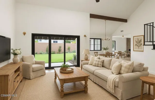 a living room with furniture and a floor to ceiling window