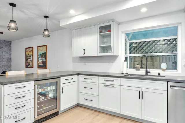 a kitchen with granite countertop white cabinets white stainless steel appliances with a sink and dishwasher